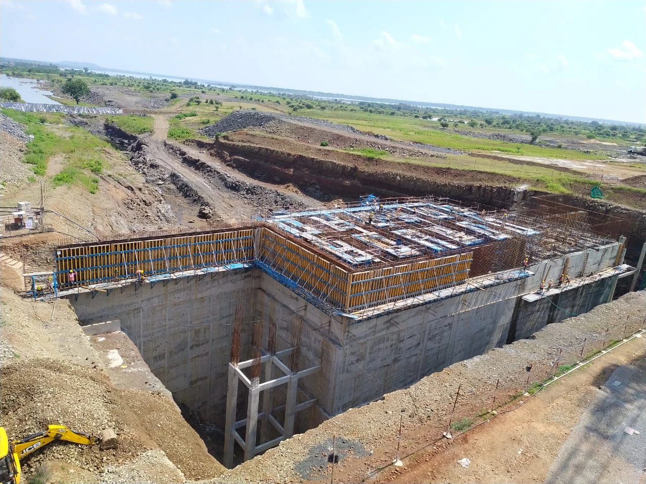 Construction-site view of a reinforced concrete structure and surrounding excavation